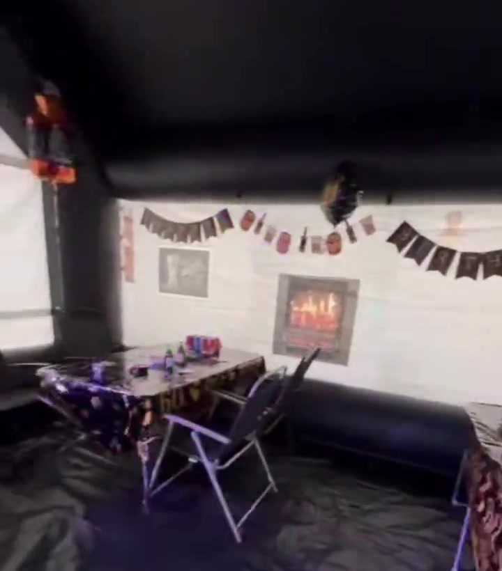 Inflatable pub interior — table, chairs, fireplace, bunting